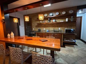 布希奥斯Aconchegante Casa Buzios的厨房配有大型木桌和椅子