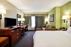 格尼芝加哥古尔尼希尔顿恒庭酒店的酒店客房配有一张床和一张书桌及一台电视