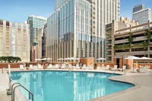 芝加哥Hilton Grand Vacations Club Chicago Magnificent Mile的城市里一个带椅子和遮阳伞的大型游泳池