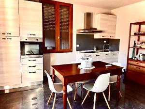 蒙特卡蒂尼泰尔梅Casa Cavour的厨房配有木桌和白色椅子
