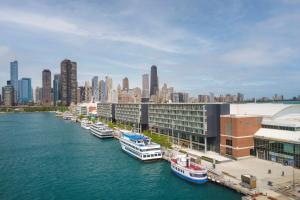 芝加哥Sable At Navy Pier Chicago, Curio Collection By Hilton的一群船停靠在一条城市的河流中