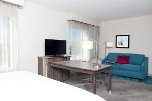 绍姆堡芝加哥绍姆堡希尔顿汉普顿套房酒店的酒店客房配有书桌和蓝色沙发。