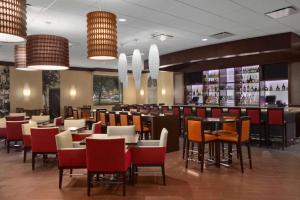 罗斯芒特Embassy Suites by Hilton Chicago O'Hare Rosemont的一间带桌椅的餐厅和一间酒吧