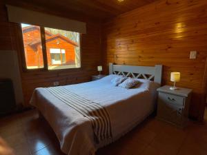 埃尔卡拉法特La Comarca Azul的小木屋内一间卧室,配有一张床