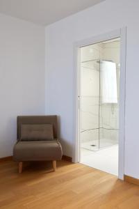 莱切Glass House - Smart Rooms & Parking的客厅配有椅子和玻璃门