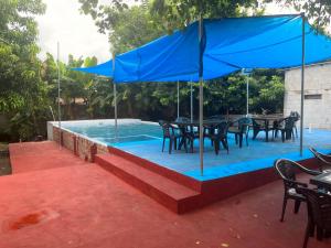 EscuintlaHotel Chulamar, Piscina y Restaurante的一个带桌椅的游泳池以及蓝伞