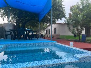 EscuintlaHotel Chulamar, Piscina y Restaurante的一个带桌子和遮阳伞的游泳池