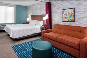 查尔斯顿Home2 Suites By Hilton North Charleston University Blvd的酒店客房,配有床和沙发