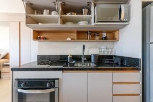 阿雷格里港LIV - Apartamento 1011的厨房配有水槽和炉灶