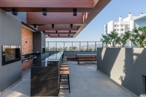 阿雷格里港LIV - Apartamento 1011的从带桌子和长凳的建筑屋顶上欣赏美景