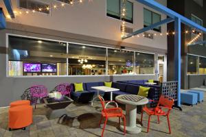 布赖恩Tru by Hilton Bryan College Station的一间设有五颜六色桌椅的餐厅和一间酒吧