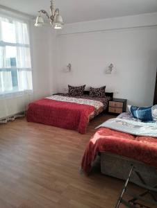 LyubintsyВілла Сади Єви的一间设有两张红色床单的床的房间