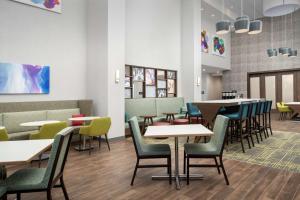夏洛特Hampton Inn & Suites Charlotte Airport Lake Pointe的用餐室配有桌椅