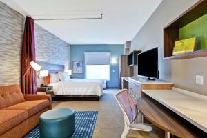 夏洛特Home2 Suites By Hilton Charlotte Piper Glen的酒店客房,配有床和电视