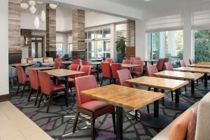夏洛特夏洛特机场希尔顿花园酒店的餐厅设有木桌和红色椅子