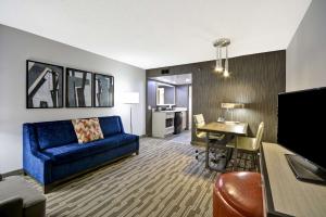 夏洛特夏洛特套房酒店的客厅配有蓝色的沙发和桌子