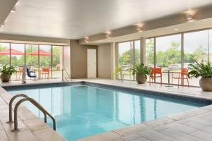都柏林哥伦布都柏林希尔顿惠庭酒店的一个带桌椅和窗户的大型游泳池