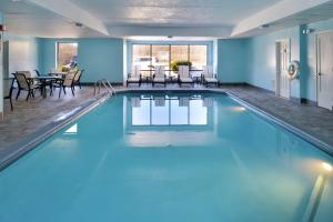 皮克林哥伦布东汉普顿酒店的一座拥有蓝色墙壁和桌椅的大型游泳池