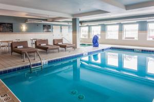 科罗拉多斯普林斯科罗拉多斯普林斯机场希尔顿恒庭酒店的一个带椅子和桌子的大型游泳池