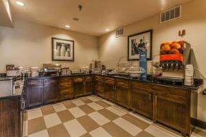 科罗拉多斯普林斯科罗拉多斯普林斯机场希尔顿恒庭酒店的厨房配有木制橱柜和柜台上的橙子
