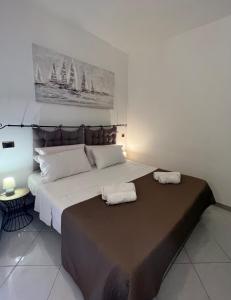 萨萨里Sassari Apartments - Maestrale的一间卧室配有一张大床和两条毛巾