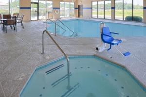 卡本代尔卡本代尔汉普顿酒店的大楼内带蓝色椅子的大型游泳池