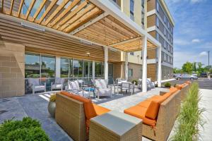 布鲁艾施Home2 Suites By Hilton Blue Ash Cincinnati的户外庭院配有橙色家具和桌椅。