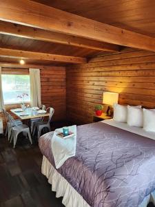 坎莫尔朗德尔山汽车旅馆的木制客房内的一间卧室配有一张大床