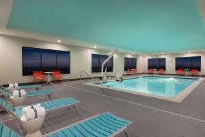 夏延Tru By Hilton Cheyenne的一座带椅子和桌子的酒店游泳池