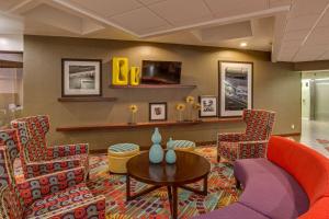 代托纳海滩代托纳赛道机场汉普顿酒店的大堂设有椅子、桌子和电视。