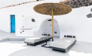 菲罗斯特法尼Rafael' s Mediteranian Cave Suites的桌子、椅子和雨伞
