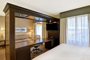 奥罗拉丹佛机场汉普顿套房酒店/盖特韦帕克的酒店客房配有书桌和床。