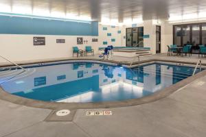 桑顿Hilton Garden Inn Denver/Thornton的一座带蓝色桌椅的游泳池