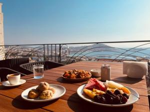 库萨达斯MONALİSA HOTELS的一张木桌,上面放着食物盘