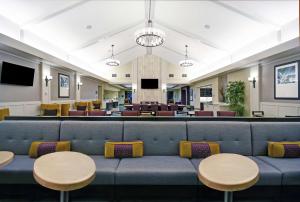 奥罗拉丹佛国际机场希尔顿酒店的一间配备有蓝色沙发和桌子的等候室