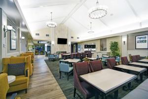 奥罗拉丹佛国际机场希尔顿酒店的用餐室配有桌椅