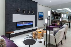 朗蒙特Hilton Garden Inn Longmont的客厅设有壁炉和紫色家具