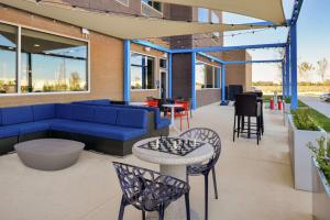 CoppellTru By Hilton Coppell DFW Airport North的庭院设有蓝色的沙发、椅子和桌子