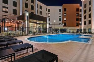 本殖民地Homewood Suites by Hilton Dallas The Colony的一座带长椅的建筑中间的游泳池
