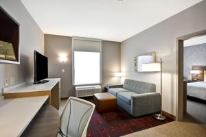 FairviewHome 2 Suites By Hilton Fairview Allen的酒店客房配有床、沙发和椅子