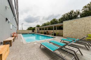 罗阿诺克Home2 Suites By Hilton Fort Worth Northlake的一座带躺椅的游泳池,位于大楼旁