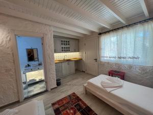 切什梅ALAÇATI XL LUXURY HOTEL的客房设有一张床和一间带窗户的厨房