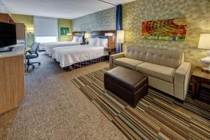 德斯坦德斯坦希尔顿欣庭套房酒店 的酒店客房配有床、沙发和电视。