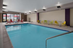 德梅因Home2 Suites by Hilton Des Moines at Drake University的游泳池位于酒店客房内,配有桌椅