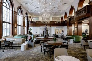 德梅因Hotel Fort Des Moines, Curio Collection By Hilton的大堂设有桌椅和吊灯。