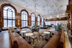 德梅因Hotel Fort Des Moines, Curio Collection By Hilton的大型大堂设有桌椅和窗户。