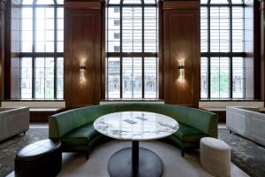 德梅因Hotel Fort Des Moines, Curio Collection By Hilton的客厅配有绿色沙发和桌子
