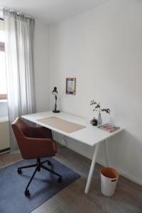 帕塞瓦尔克Wohnen im alten Standesamt的客房内的白色书桌和椅子