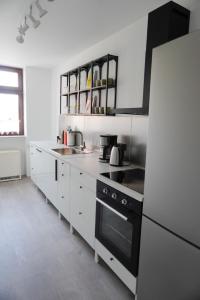 帕塞瓦尔克Wohnen im alten Standesamt的厨房配有白色橱柜和黑炉灶烤箱。