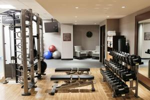 Urbandale厄本代尔司丽普酒店的一间健身房,配有数台跑步机和举重器材
